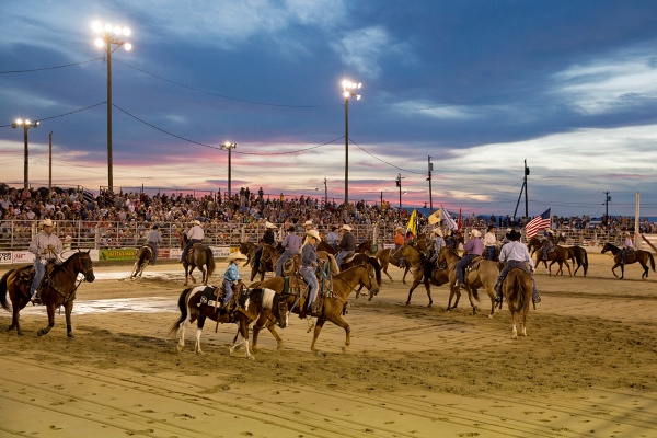 Participants in the Cowtown Rodeo parade around the arena before competing in events like bull riding, steer wrestling, and barrel racing. (Lindsay Lazarski/WHYY)
