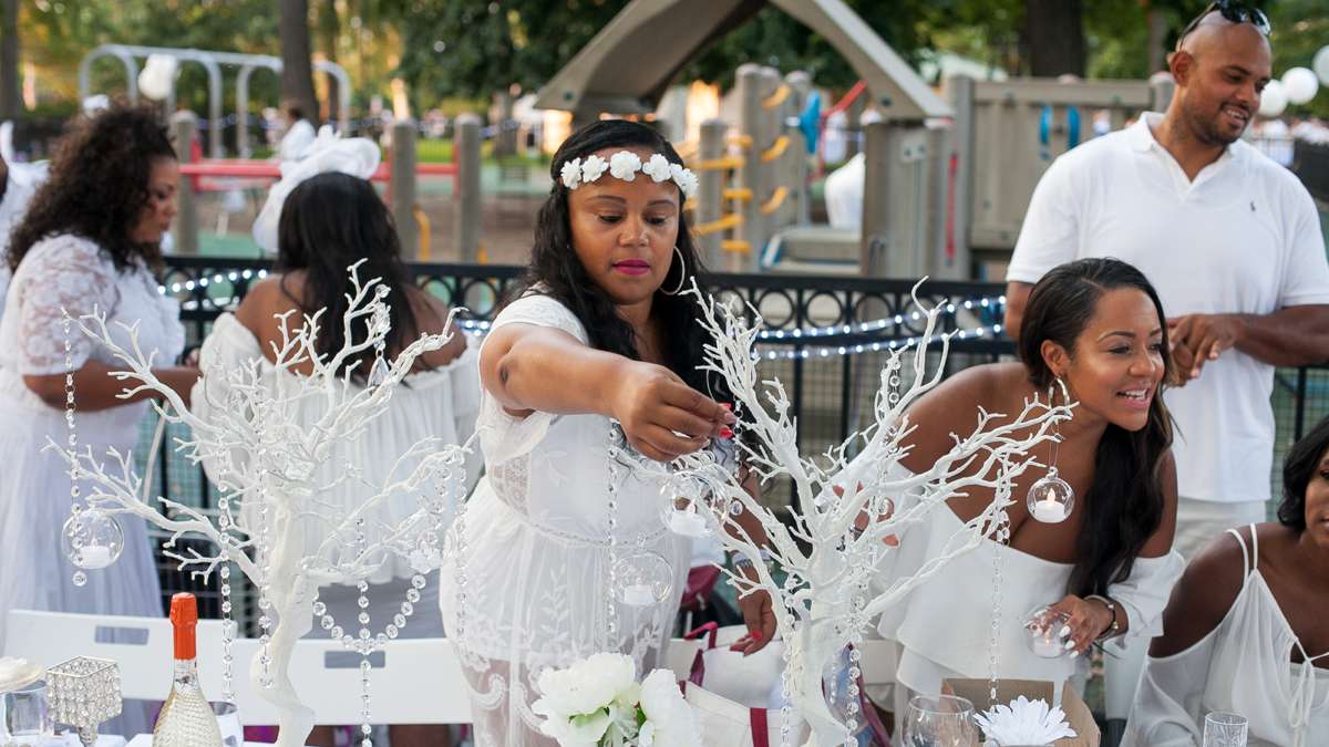 Ayesha Bailey of Philadelphia decorates her table at Dîner en Blanc in Franklin Square Thursday evening. (Brad Larrison for NewsWorks)