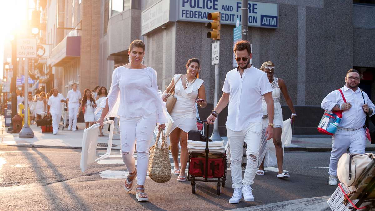 As the sun sets, diners make their way to Franklin Square Park for the annual Dîner en Blanc at Franklin Square Park. (Brad Larrison for NewsWorks)