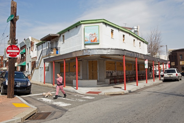 The property formerly known as Colombo's Restaurant sits vacant with windows boarded up at the corner of East Passyunk Avenue and Juniper Street. (Lindsay Lazarski/WHYY)