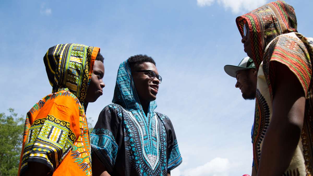 Two boys talk with their friends at Clara Muhammad Square