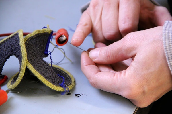 <p><p>A wire made from nickel titanium, a shape memory alloy, controls the movement of the "knitbot", a knitted robot being researched at Drexel's ExCITe Center. (Emma Lee/for NewsWorks)</p></p>
