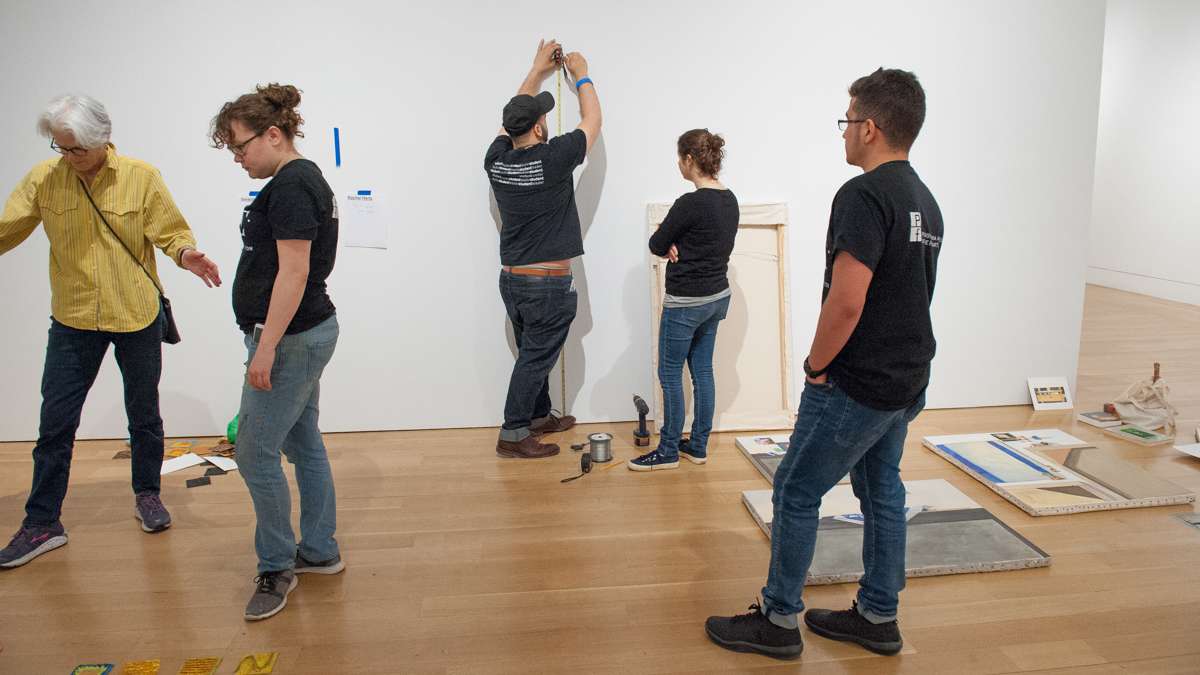 PAFA faculty member Jan Baltzell (left) helps students exhibit their work.