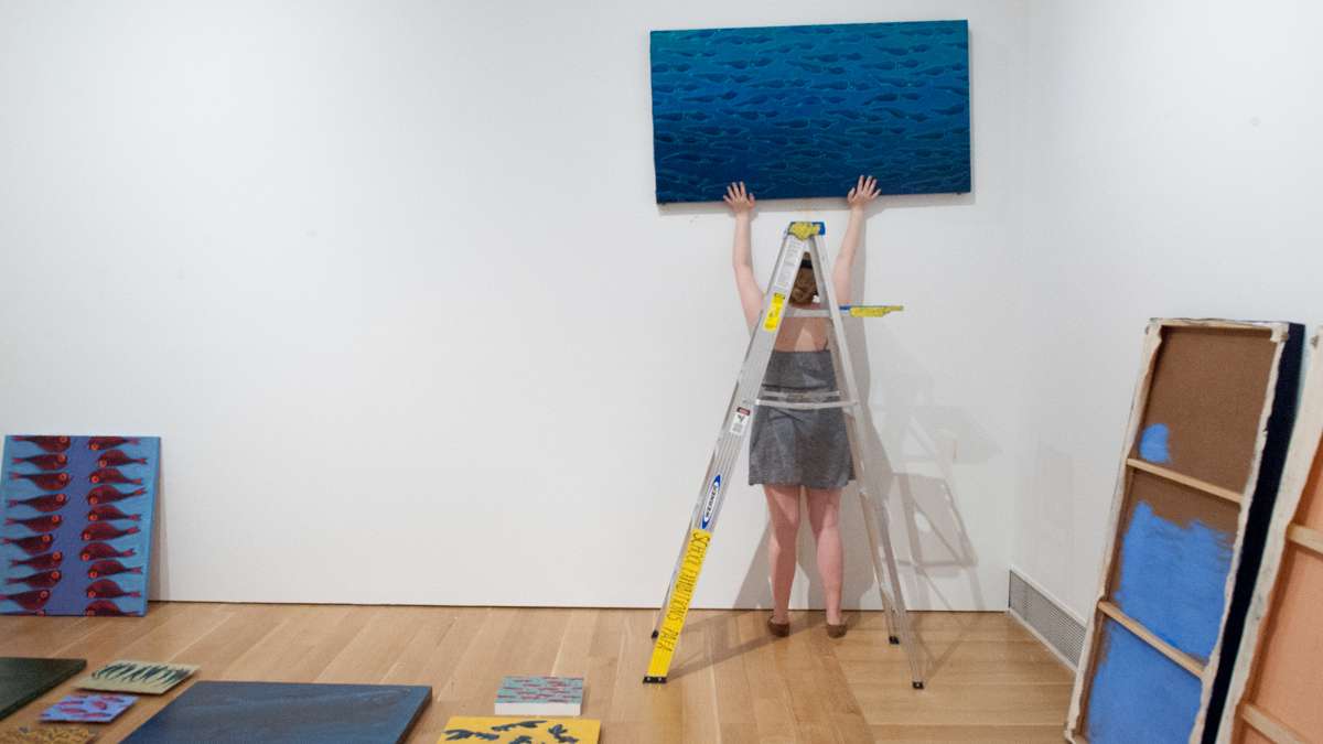 Olivia Losee-Unger hangs one of her paintings.