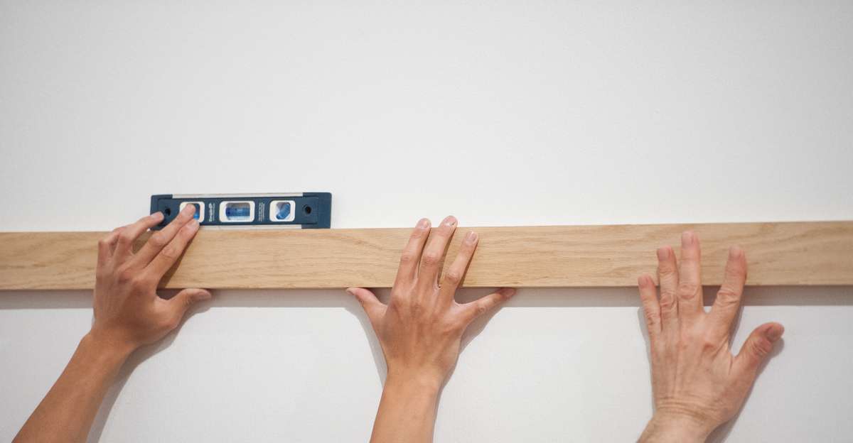 A student and a faculty member level a support for a painting.