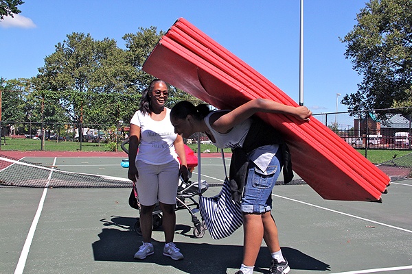 Coach Latifa Roberts watches as her competitive spirit team cleans up after a summer practice at Reyburn Park.
