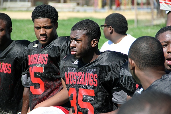 John Young (center), a rising senior at Dobbins-Randolph High School, says his grades improved after he joined the football team. He is a linebacker who aspires to play running back this year.