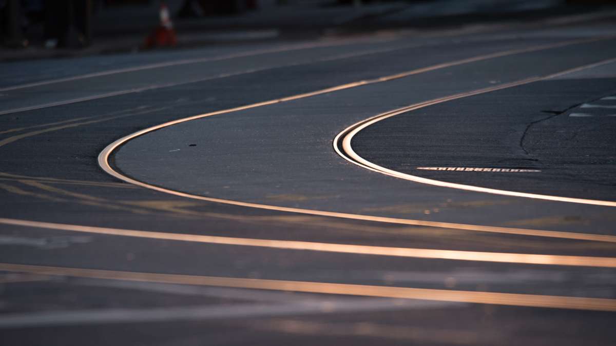 Curving trolley tracks on Girard Avenue shine pinkish-silver against the gray of the street in the pre-dawn light.