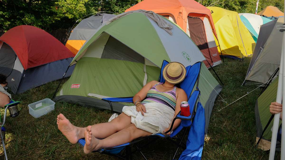 A camper catches up on her sleep in the shade of a tent in the campgrounds.