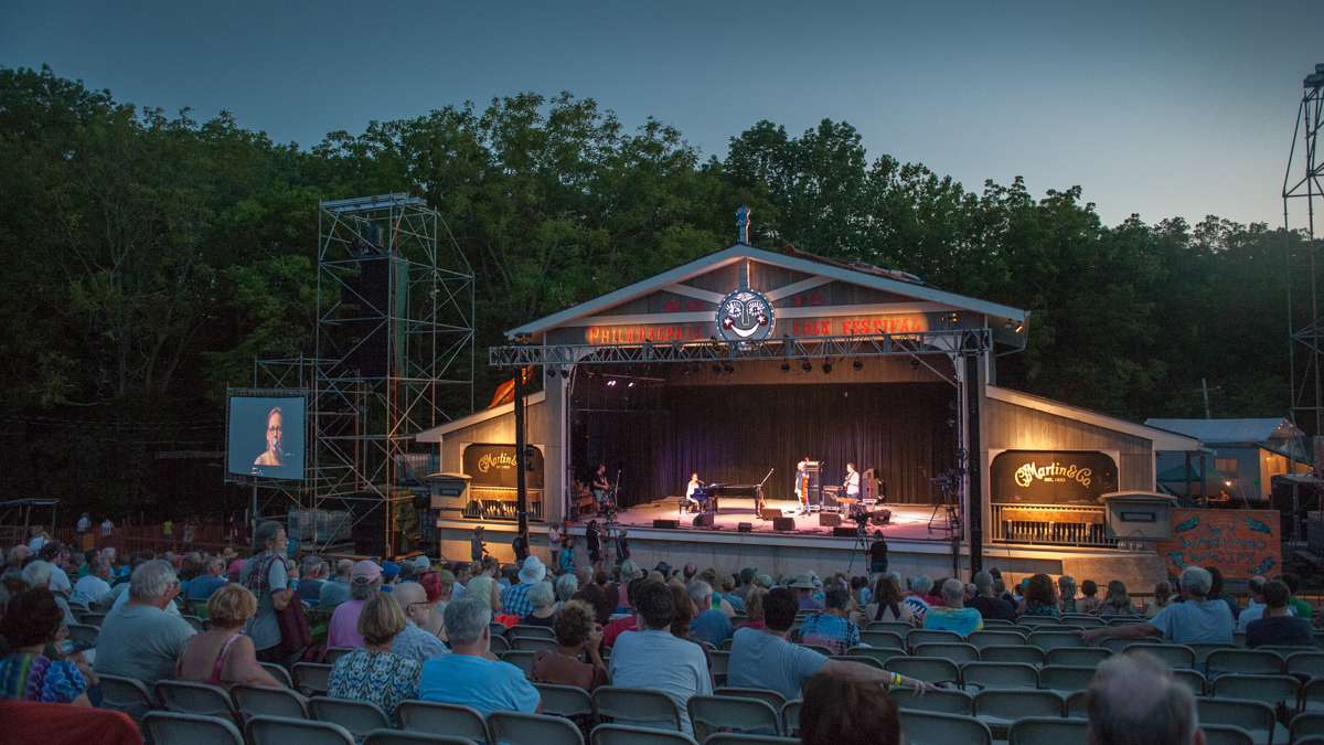 As the sun sets the audience listens to Iris DeMent.