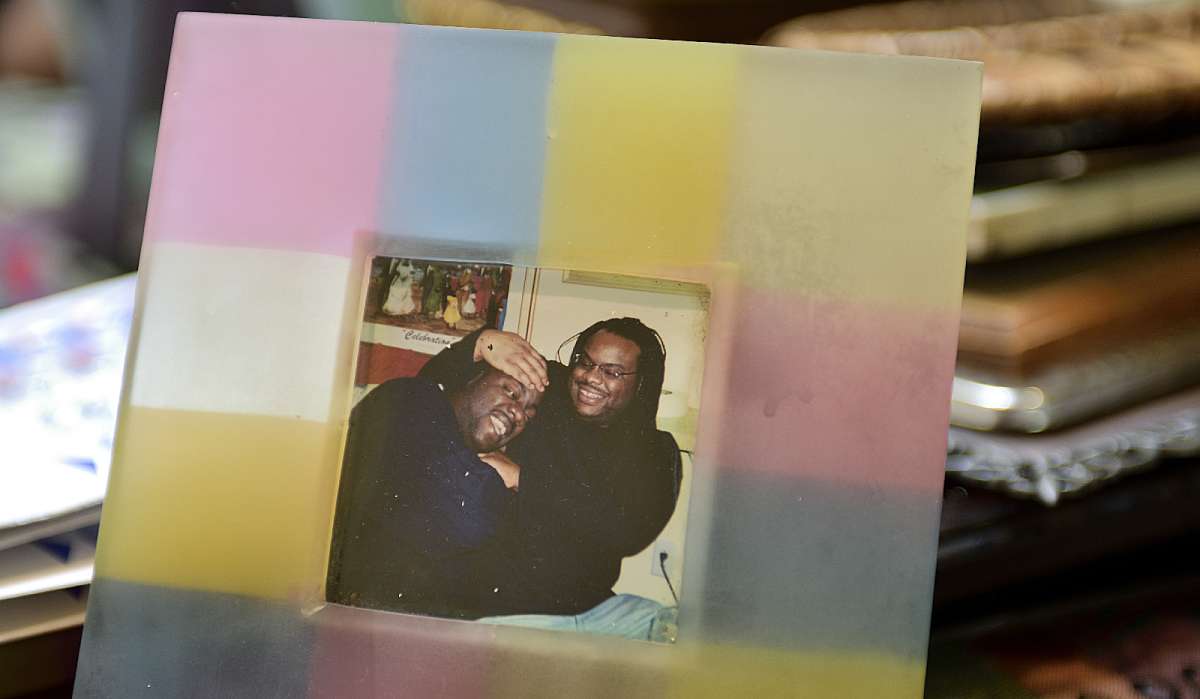 Meneek Jones and Michelle Witherspoon go through a collection of framed family pictures.
