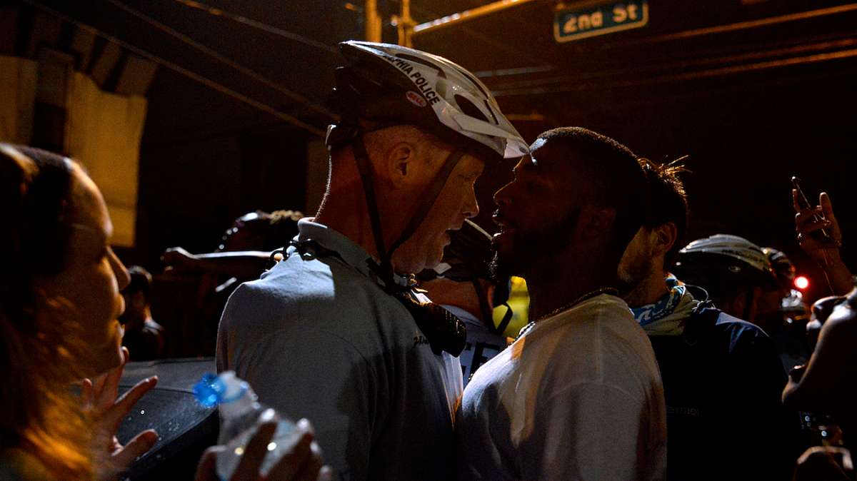 A police officer and protester square off at the intersection of 2nd and Allegheny streets after one foreign protester was arrested and briefly detained for disorderly conduct.