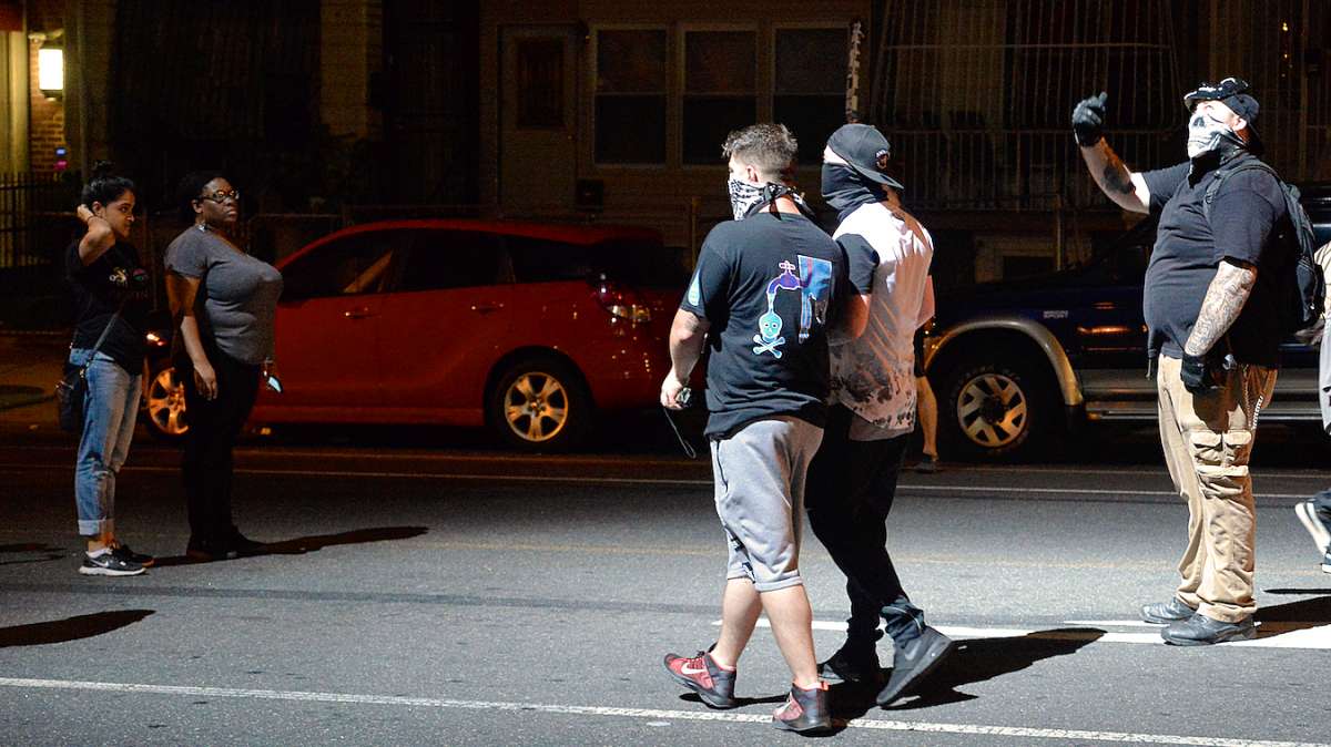 Megan Malachi, spokesperson for the Philly Coalition for REAL Justice is seen on the left as she and others watch the British men who joined the protest.