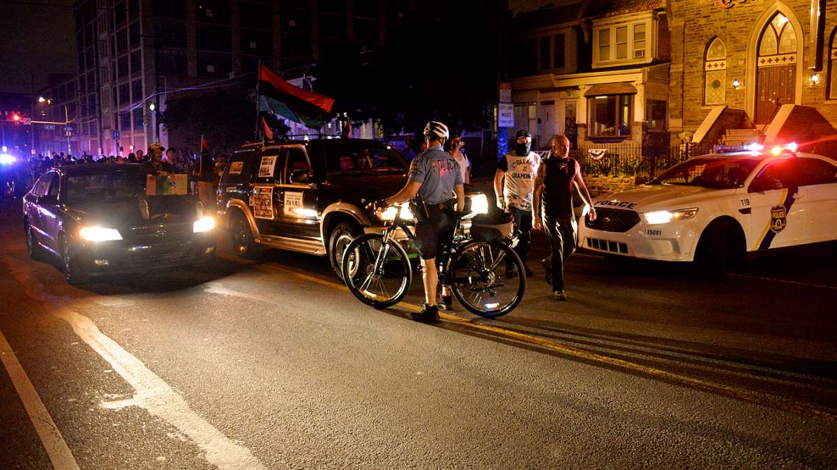 On Allegheny two men walk past police officers as the rest of the marchers hold back.