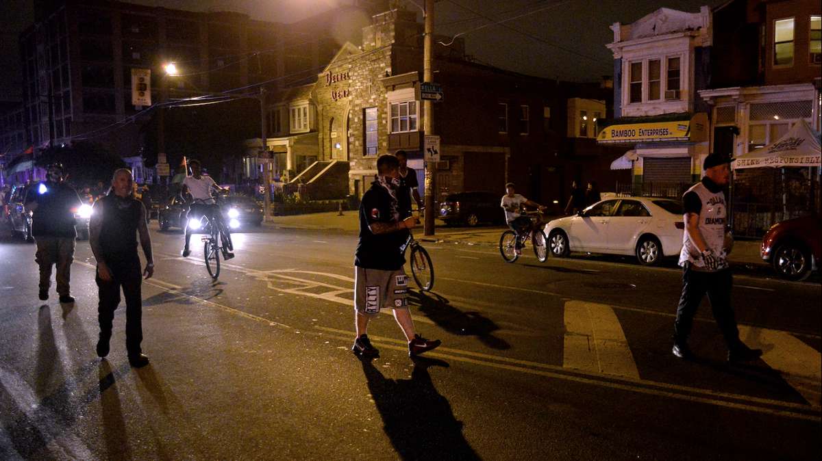 Protesters march, while one (seen on the left) shines a flashlight up towards the circling PPD helicopter.