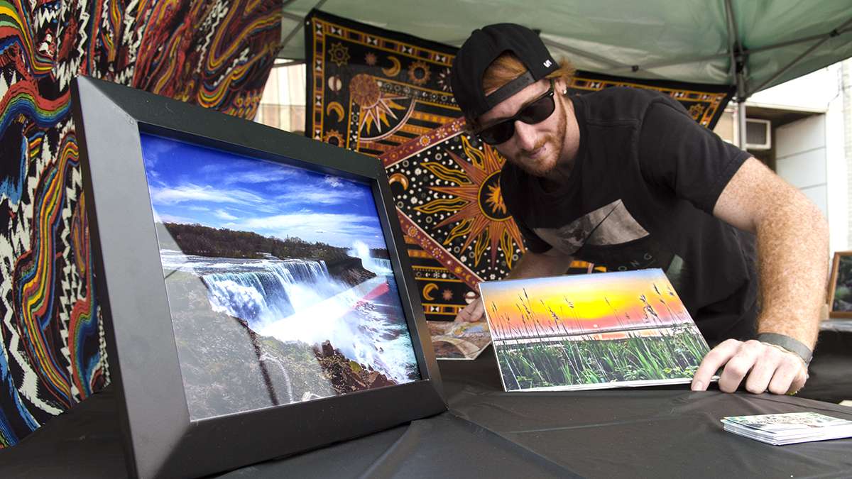 T.J. Kurtyka sets up some of his photographs for sale at the first Jersey Fringe in Hammonton. (Anthony Smedile for NewsWorks)