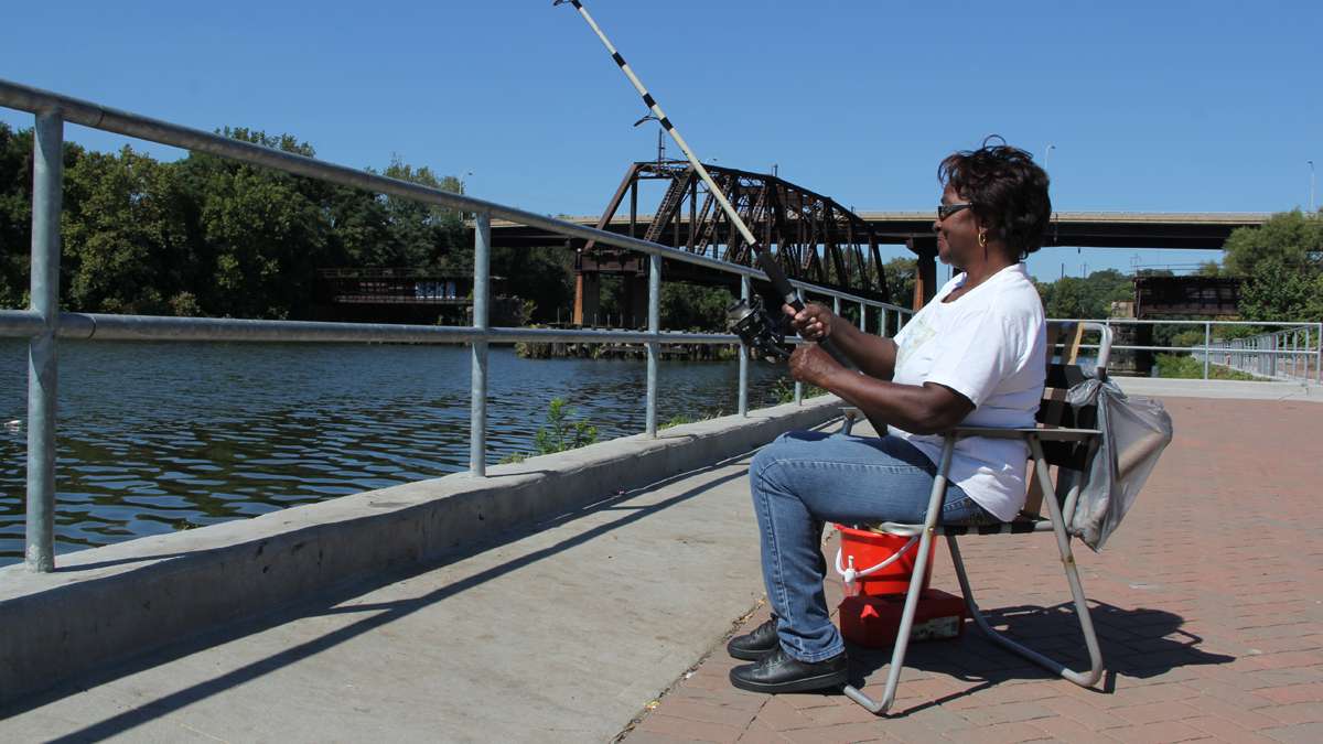Estelle Terrell enjoys a day of fishing on the Schuylkill River at Grays Ferry Crescent. (Emma Lee/for NewsWorks)