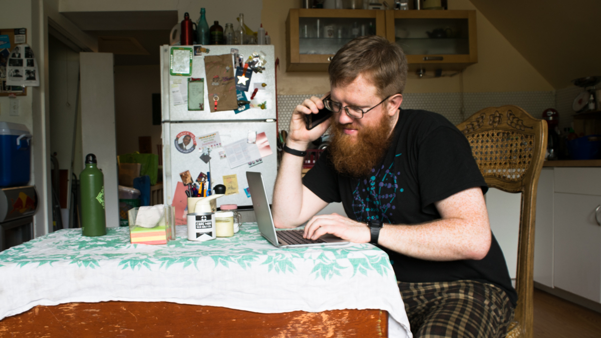  Alex Spencer sits at his table making phone calls to be a test subject for new studies. (Paige Pfleger/WHYY) 