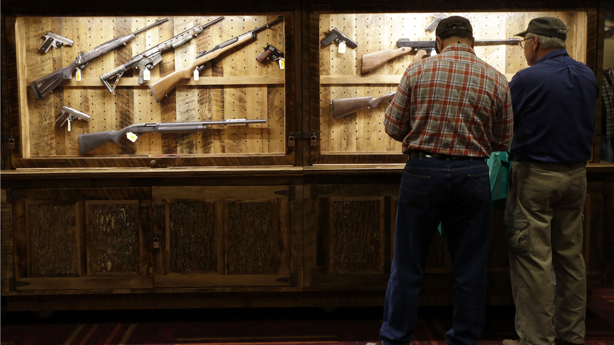 File image of attendees looking over a wall of guns available to win in a raffle at the National Rifle Association's annual convention in Friday