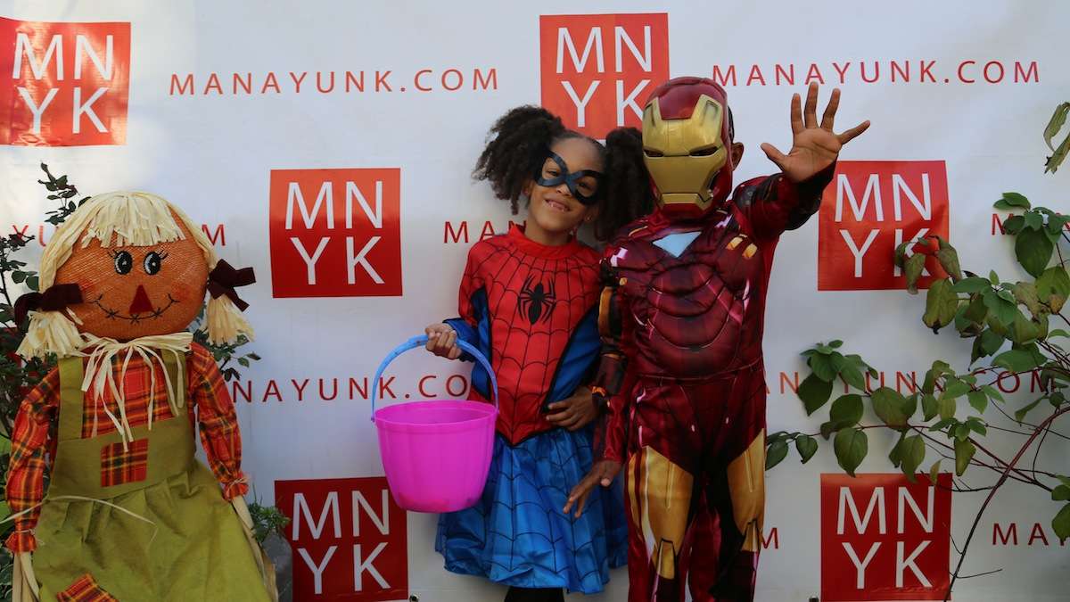 Superheroes Cloe and Germaine Lewis strike a pose while trick-or-treating on Main Street. (Natavan Werbock/for NewsWorks)