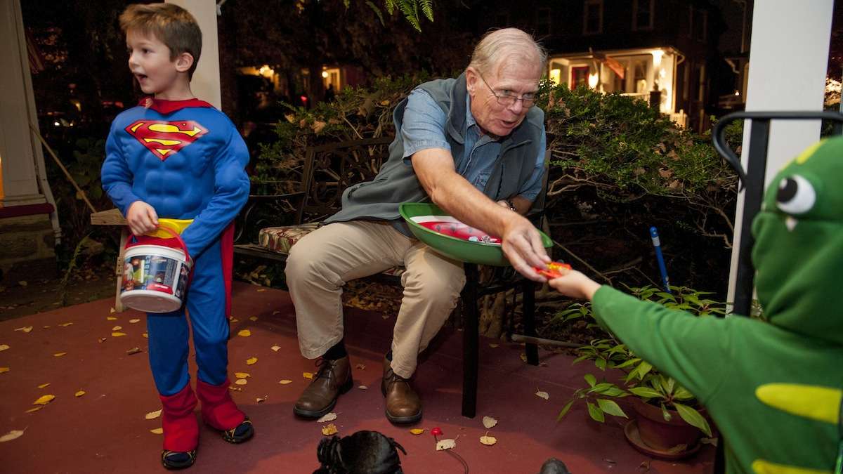 Chestnut Hill resident Jim McCafferty passes out candy from his porch on Halloween night. (Tracie Van Auken/for NewsWorks)