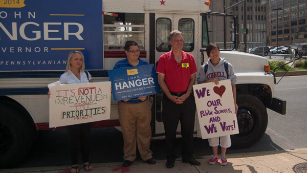  Pa. gubernatorial candidate John Hanger stands in front of his red, white and blue bus with Amy Chen (right) a junior at Science Leadership Academy, and Maureen Smith (left), a junior at CAPA. Both girls sit on the superintendent's advisory board for the School District of Philadelphia. (Ann Marie Awad/for NewsWorks) 