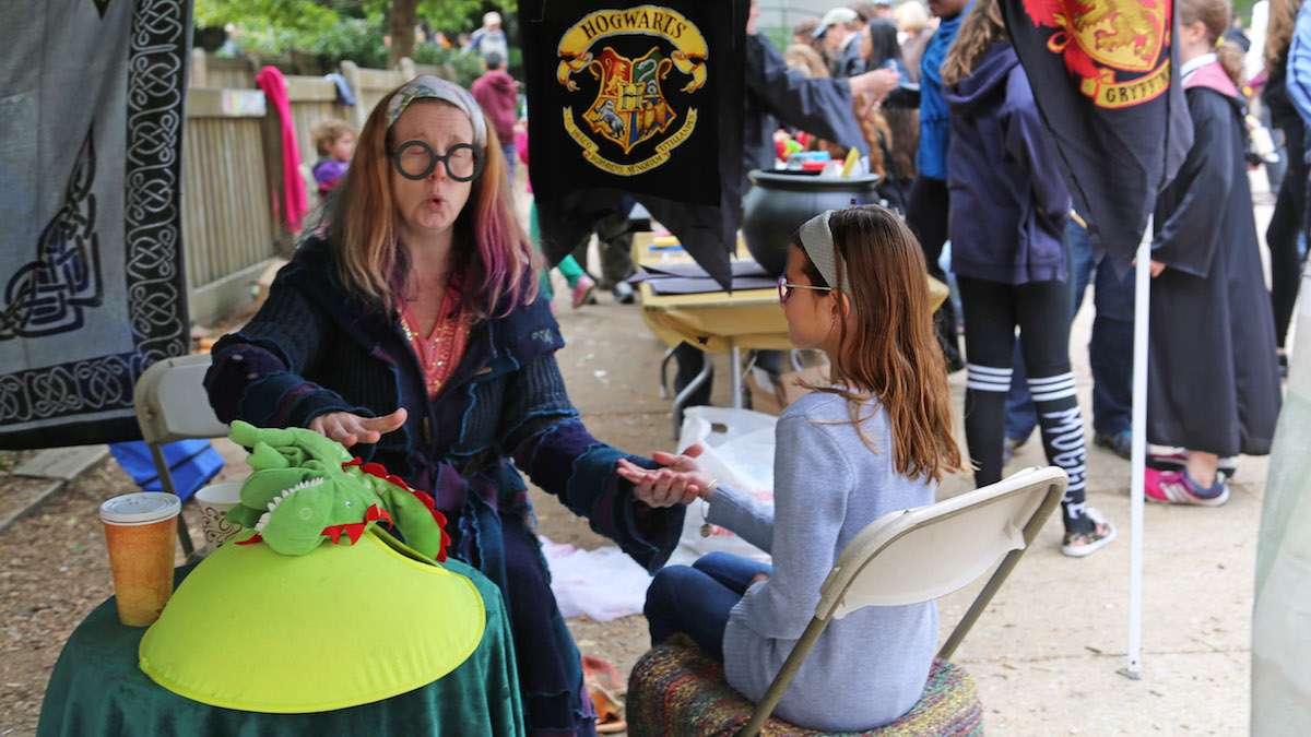 10-year-old Ava getting a palm reading at the Professor Trelawney's Predictions booth (Natavan Werbock/for NewsWorks)