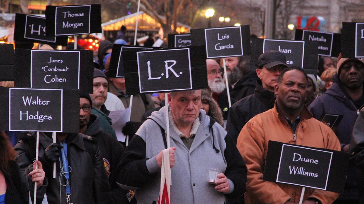  Participants in the Homeless Memorial Day ceremony carry signs bearing the names of 127 homeless and formerly homeless people who died in 2013. (Emma Lee/for NewsWorks) 