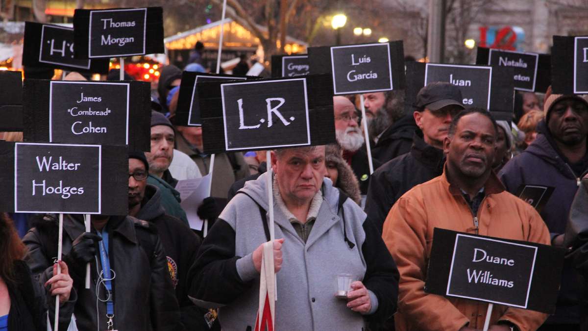 Participants in the Homeless Memorial Day ceremony carry signs bearing the names of 127 homeless and formerly homeless people who died in 2013. (Emma Lee/for NewsWorks)