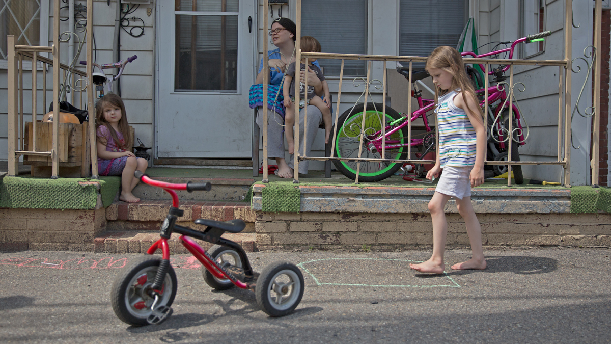  Heather Hoover sits on her porch while her children, Emmalie, 6, Hannah, 3, and Jared, 1, play in front of their home in Mahanoy City, Pennsylvania.  Hoover, a mother of eight, hopes to move to a place with more space for her children to play. She said it seems like the town is falling apart.  (Lindsay Lazarski/WHYY)  