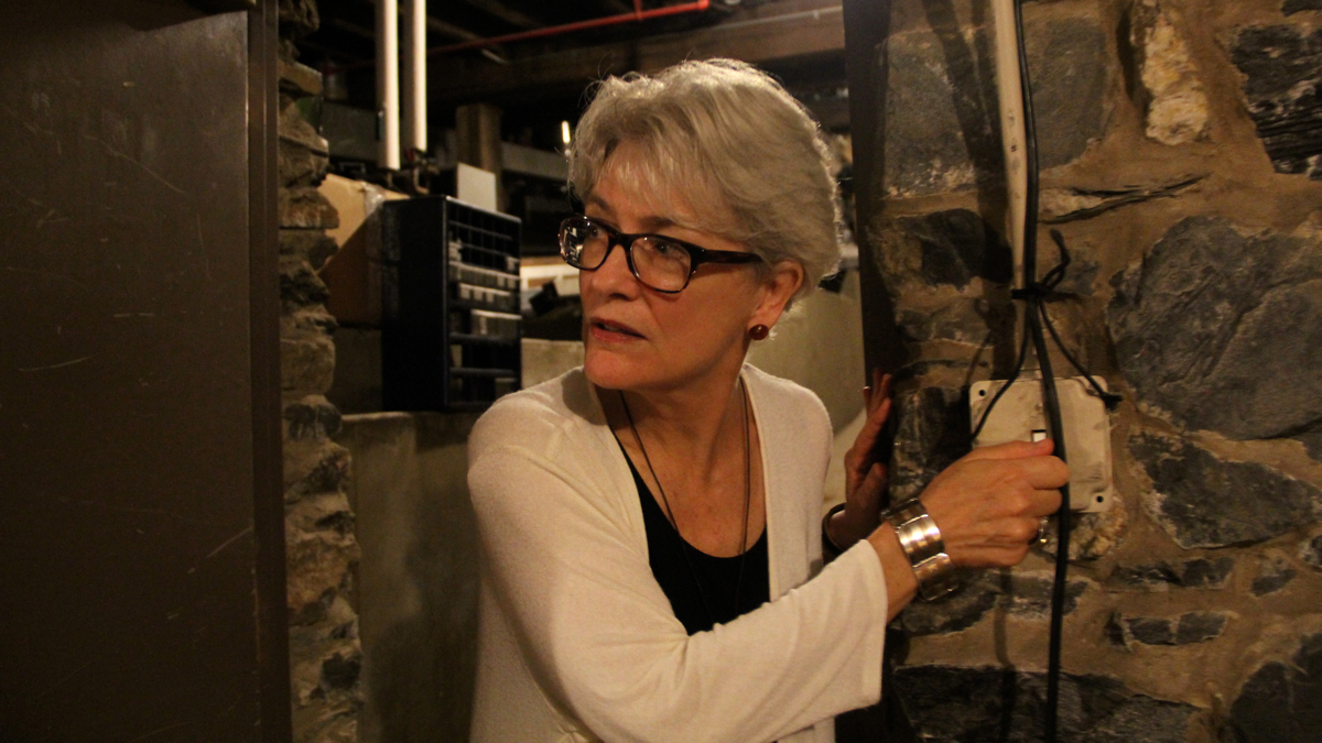  Author Leslie Stainton, who wrote a history of Lancaster's Fulton Theater, enters a basement room defined by the walls of an 18th century prison. (Emma Lee/WHYY) 