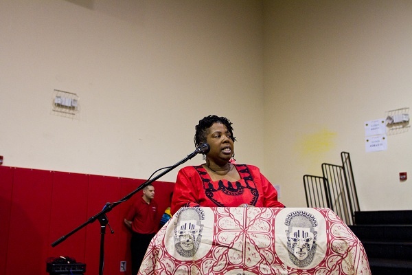 Christine 'Mamma Chris' Wiggins, founder and CEO of Imhotep Charter in East Germantown, speaks to student athletes and attendees. (Brad Larrison for NewsWorks)
