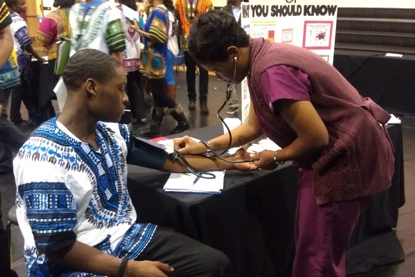<p><p>Imhotep Charter freshman Rahmir Johnson gets his blood pressure checked at the LaSalle Neighborhood Nursing Center table during the school's community health fair. (Yasmein James/for NewsWorks)</p></p>
