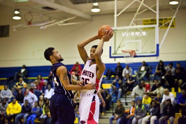 Imhotep Forward Basil Thompson makes a pass over Austin Hawkins of Philadelphia Electrical. (Brad Larrison/for NewsWorks)
