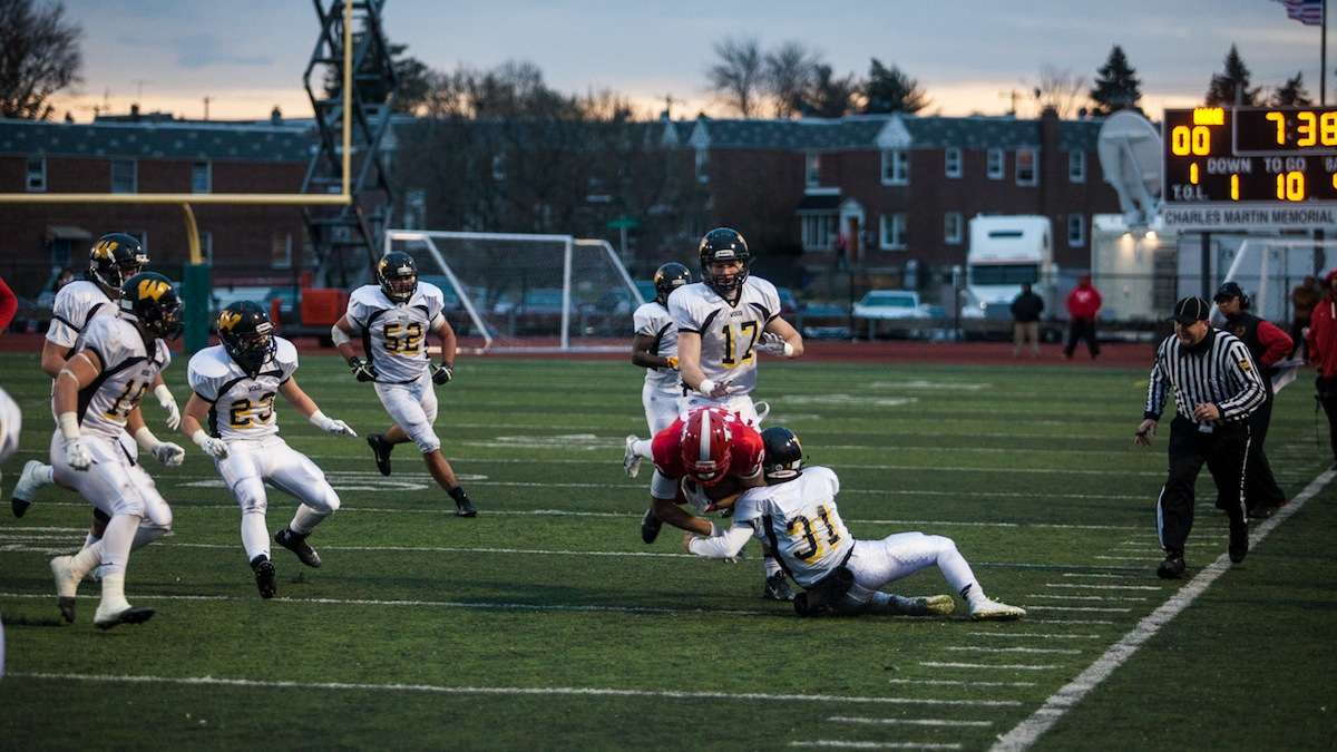 Imhotep's DJ Moore is tripped up by Dan Freeman of Archbishop Wood. (Brad Larrison/for NewsWorks)