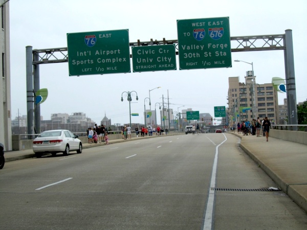 People lining the Walnut Street Bridge, taking pictures of Schuylkill flooding. (Kimberly Paynter/For NewsWorks)