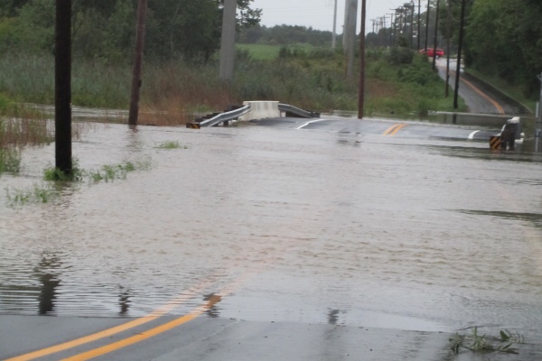 Dragon Run Creek over flows its banks and on to a local road near the Delaware City Refinery.  (John Mussoni/for Newsworks)