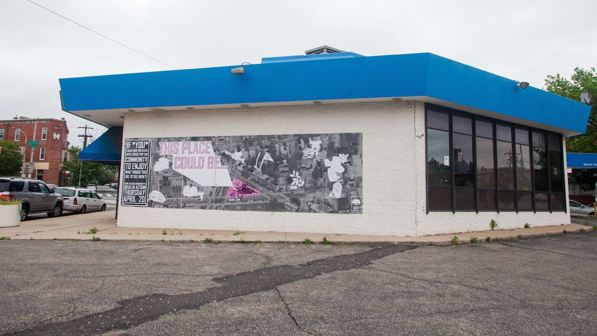 A shuttered United Bank near 38th and Lancaster Avenue is in the process in being converted into a community space. A poster for a meeting on the use of the lot and building is plastered to the wall. (Brad Larrison for NewsWorks)
