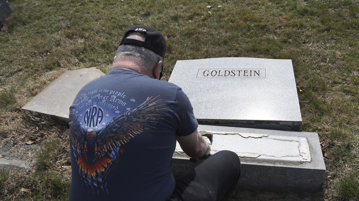  Trump supporter Bob, who declined to give his last name, volunteers his time and prepares the base of a damaged headstone Tuesday, Feb. 28, 2017, in Philadelphia. Scores of volunteers are expected to help in an organized effort to clean up and restore the Jewish cemetery where vandals damaged hundreds of headstones. (AP Photo/Jacqueline Larma) 
