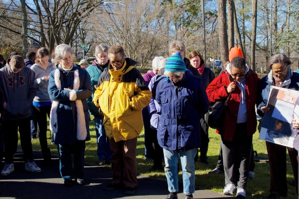 <p>Volunteers bow their heads in a prayer for the victims.
( Jana Shea /for NewsWorks )</p>
