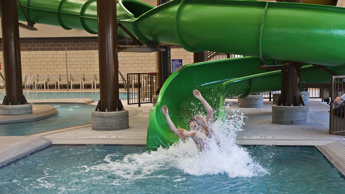 Justin Riley tests the new water slide at the Salvation Army Kroc Center in Camden. (Kimberly Paynter/WHYY)