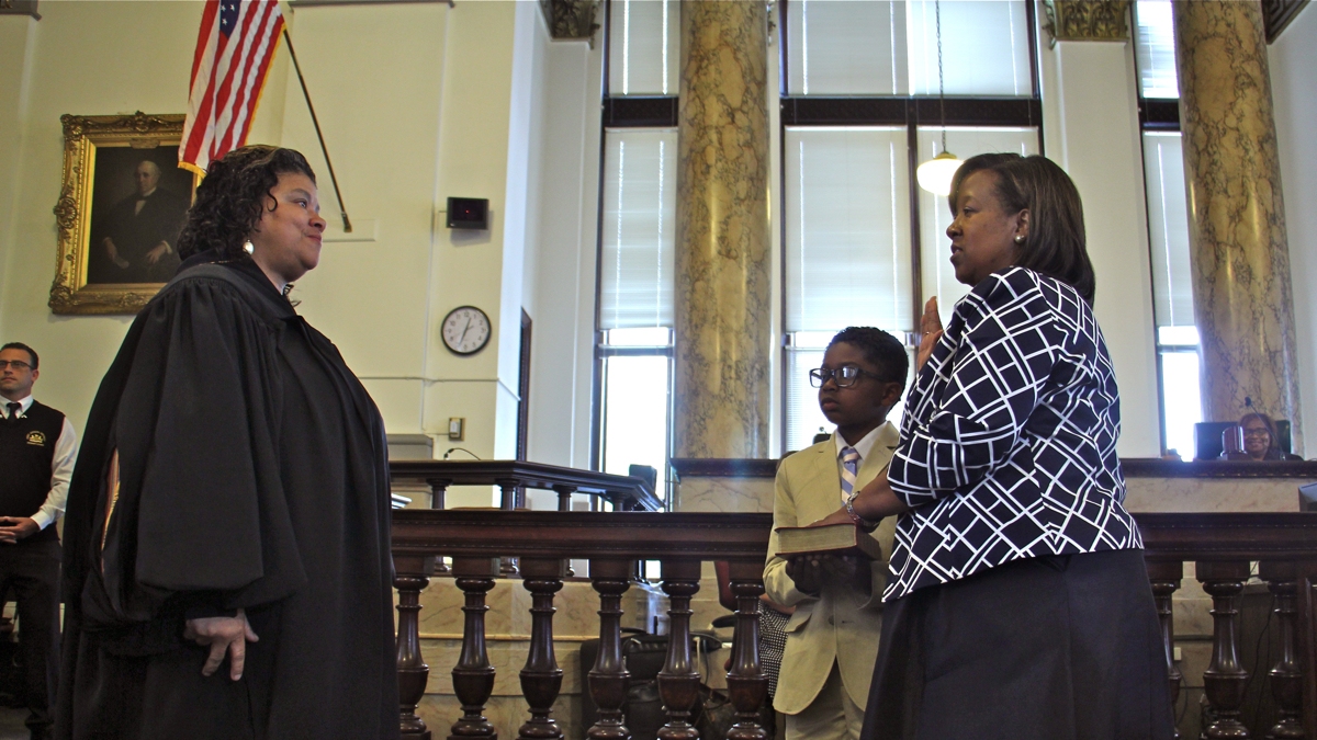   With her son by her side, Kelley B. Hodge is sworn in as Philadelphia District Attorney by Court of Common Pleas Judge Sheila Woods-Skipper. (Emma Lee/WHYY)  
