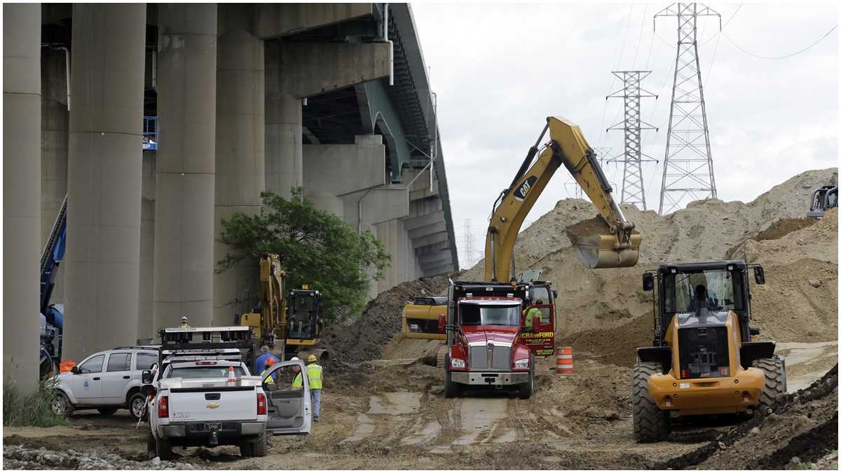  Crews remove dirt from the base of columns supporting  I-495 in 2014. (AP Photo/Patrick Semansky)  