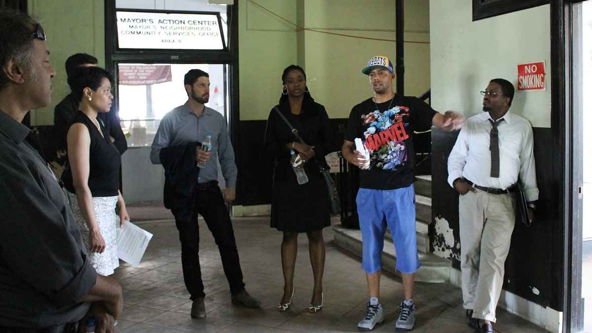  Standing in Town Hall, Rob Wheeler from Wired Beans explains the state of Germantown to Ben Miller and other community stakeholders. (Matthew Grady/for NewsWorks) 