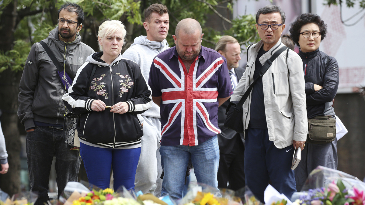  People look at flowers near London Bridge following Saturday's attack in London, Monday, June 5, 2017. Police arrested several people and are widening their investigation after a series of attacks described as terrorism killed several people and injured more than 40 others in the heart of London on Saturday.  (Isabel Infantes/PA via AP) 