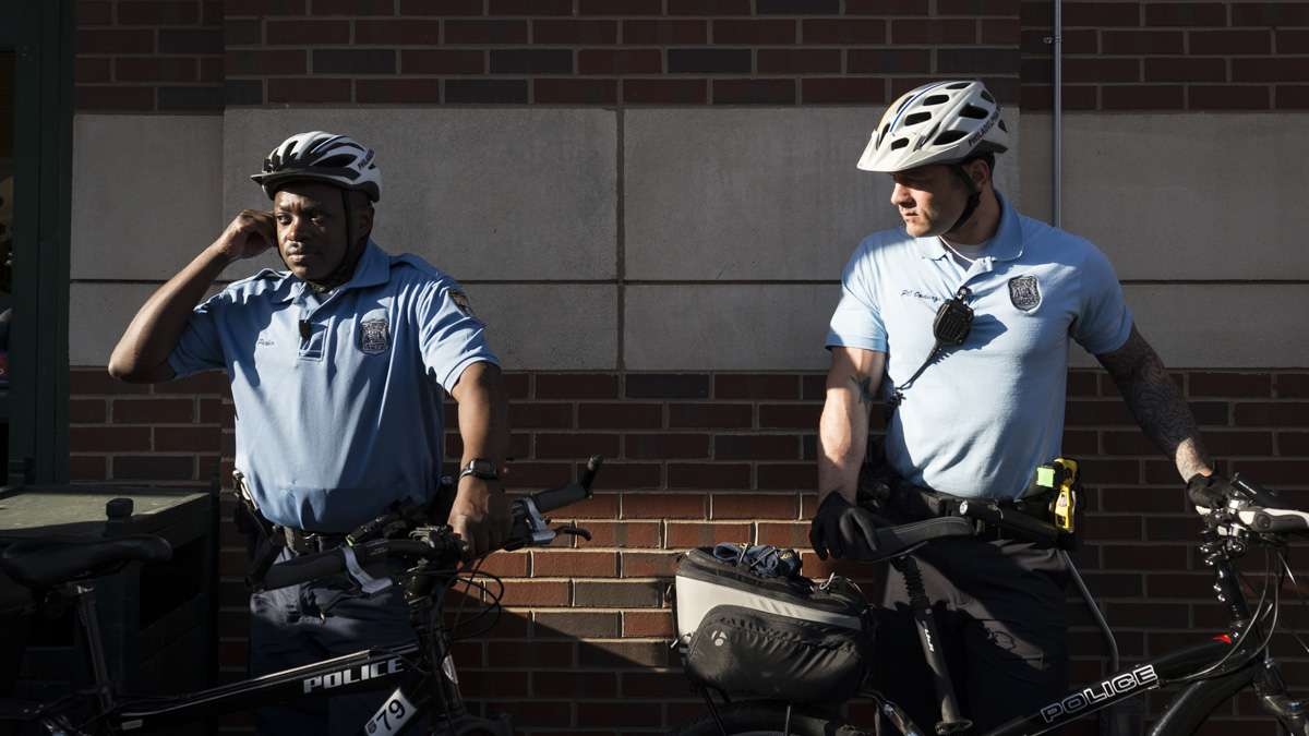 Two officers stand to the side as tensions rise outside of Whole Foods on South Street.