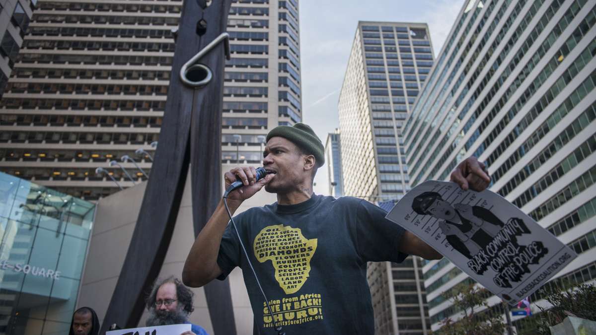 Activist Diop Olugbala speaks at the rally before circulating a petition that calls for police hiring, firing and internal investigations to be carried out at a community level.
