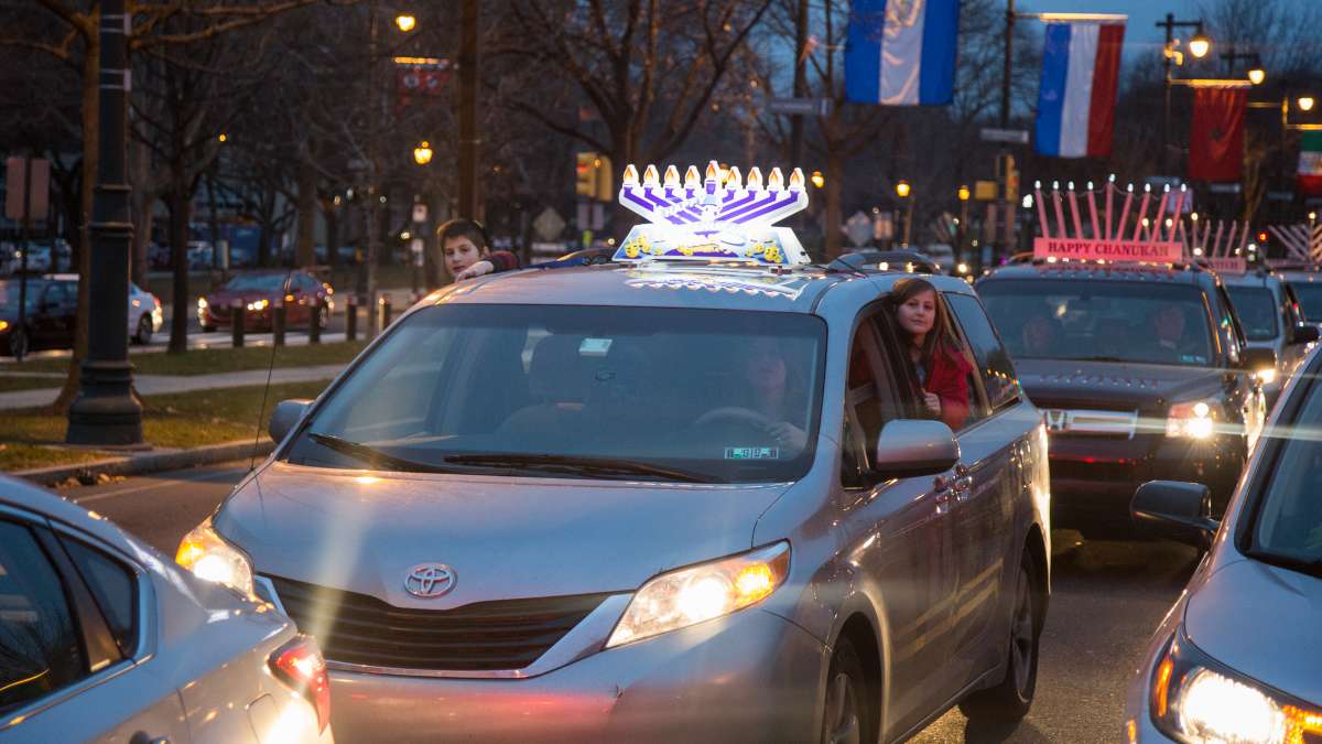 Children hang from the windows as the parade makes its way down the Ben Franklin Parkway toward City Hall.