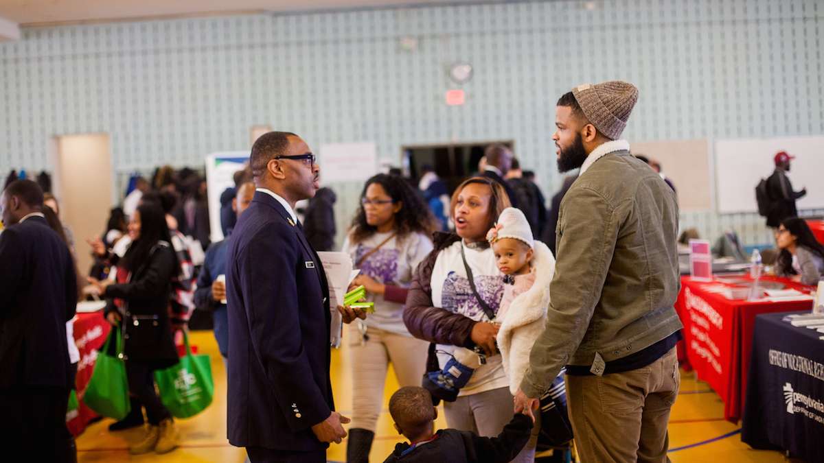 Captain Sean Mack of the Philadelphia Fire Department walked the floor talking to potential new recruits at a job and services fair at Girard College. (Brad Larrison for NewsWorks)