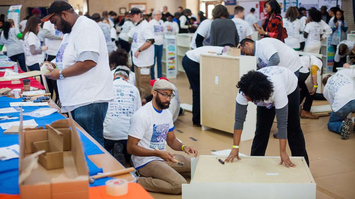 Volunteers with the organization Read By 4th -- a literacy program sponsored by the Free Library of Philadelphia -- build bookshelves. (Brad Larrison for NewsWorks)